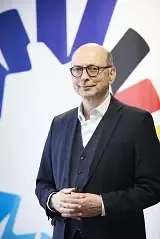 Dr. Johannes Nießen, Kommissarischer Leiter des Bundesinstituts für Öffentliche Gesundheit, steht vor dem Logo des Bundesinstituts