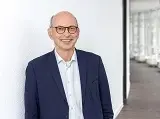Dr. Johannes Nießen, Kommissarischer Leiter des Bundesinstituts für Öffentliche Gesundheit, stehend vor weißer Wand im Flur