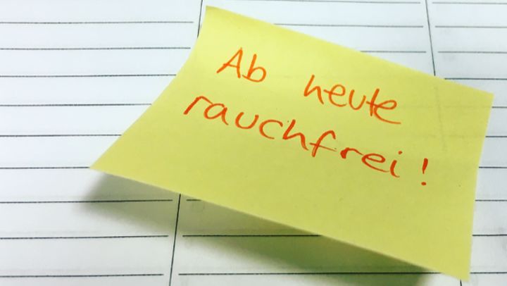 Gelber Post-it auf einem Kalenderblatt mit Angabe "Ab heute rauchfrei"