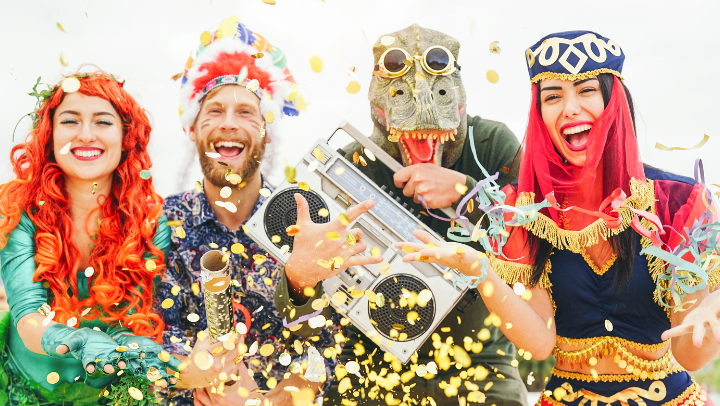 Vier junge Menschen sind kostümiert und feiern fröhlich.